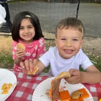 Two young friends smiling during an outdoor snack